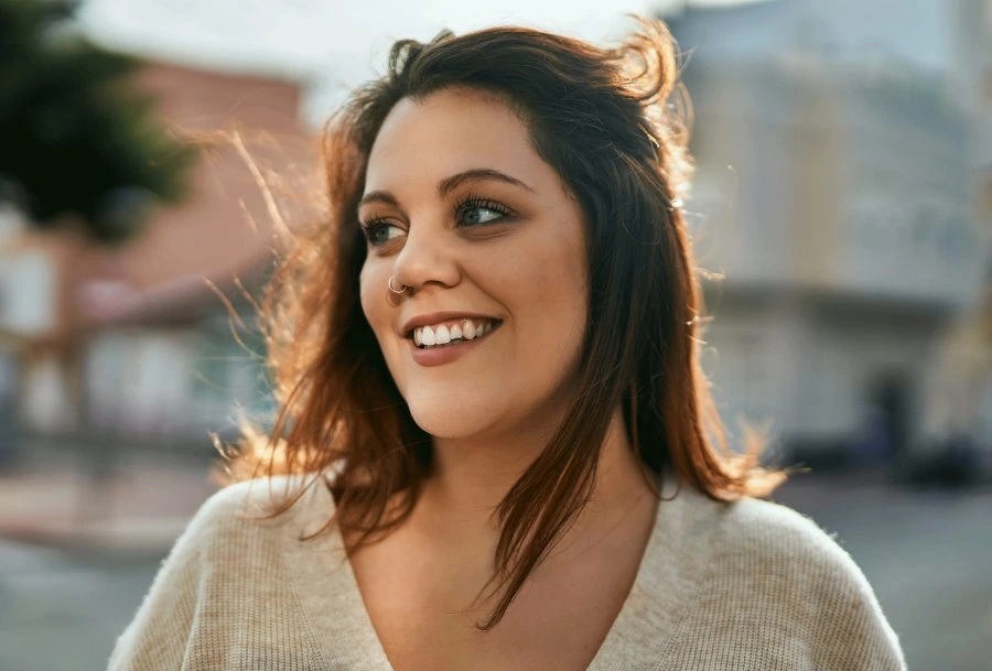 young woman smiling while facing on her right